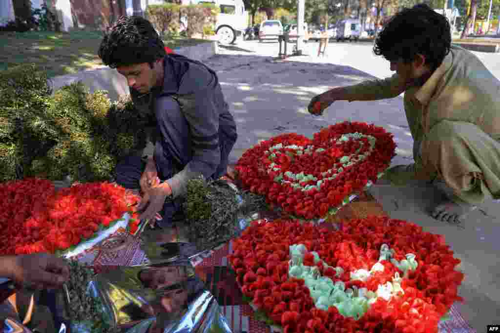 Pakistani vendors prepare heart-shaped bouquets for sale ahead of Valentine&#39;s Day along a street in Islamabad on February 13.