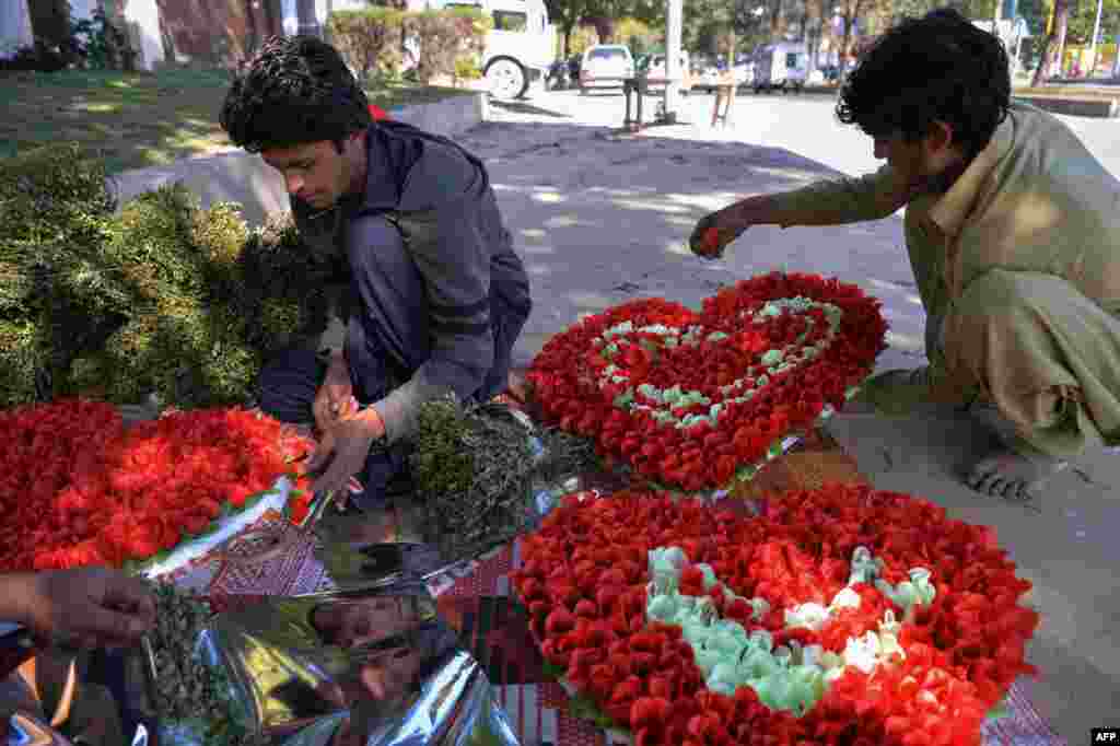 Pakistani vendors prepare heart-shaped bouquets for sale ahead of Valentine's Day along a street in Islamabad on February 13.