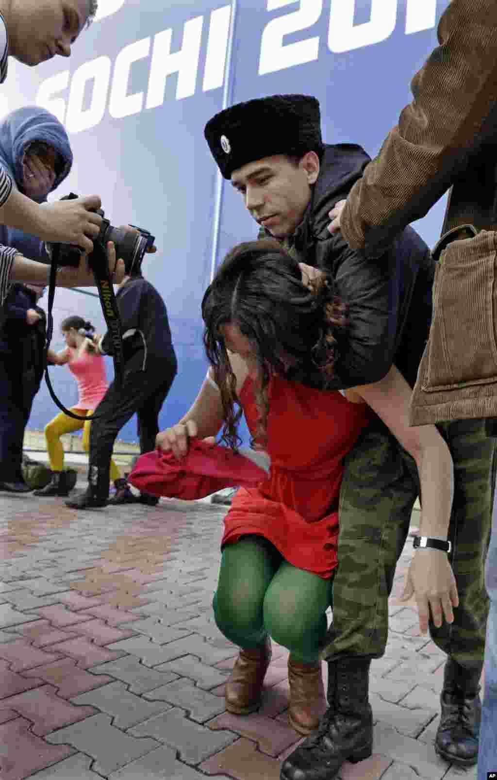 A member of Pussy Riot is restrained by a Cossack after the attack in Sochi.