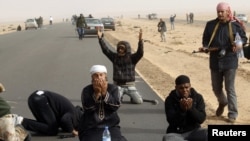 مخالفان معمر قذافی در حال نماز در نزدیکی محل نبرد رأس لانوف، ۴ مارس ۲۰۱۱.
