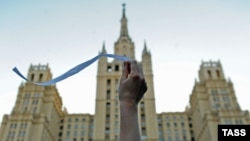 An opposition activist waves a white ribbon on Kudrinskaya Square in central Moscow.