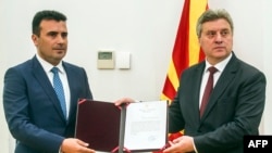 Macedonian President Gjorge Ivanov (right) poses for photographers as he gives a mandate to form a government to Social Democrat leader Zoran Zaev in Skopje on 17 May 2017