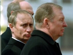 Володиир Путін дивиться з-за плеча Леоніда Кучми, а за Путіним стоїть Олександр Лукашенко.