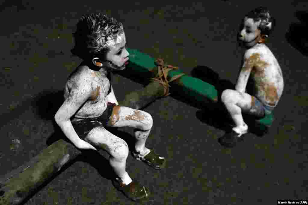 Two boys take part in a parade called La Calabiuza on the eve of the Day of the Dead in Tonacatepeque, 20 kilometers north of San Salvador, El Salvador. (AFP/Marvin Recinos)