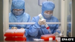 China -- Workers in protective suits work at the production line manufacturing detection kits for the new coronavirus at a company, as the country is hit by an outbreak of the new coronavirus, in Taizhou, Jiangsu province, January 29, 2020