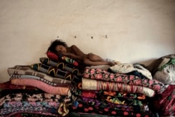 A girl naps on a pile of mats in a Romany village near Bukhara in 2010.