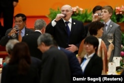 Alyaksandr Lukashenka (center), his son Nikolai (right), and Cambodian Prime Minister Hun Sen make a toast during a banquet in Beijing last May. The Belarusian president describes himself as someone "who does not drink much."