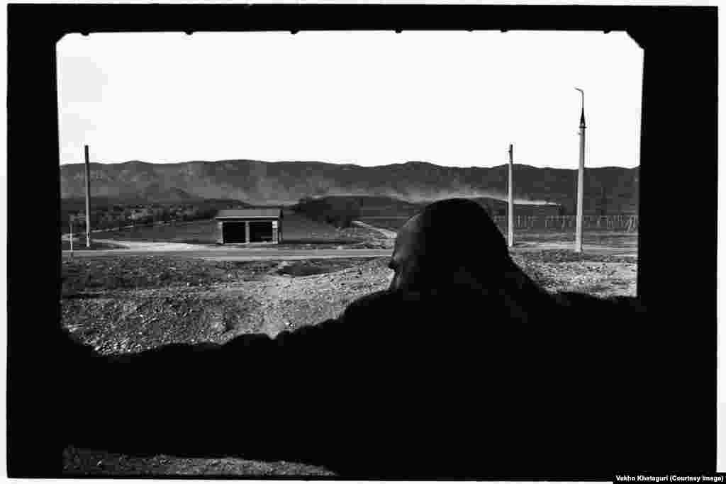 A passenger watches the landscape as his train rolls through Uplistsikhe.