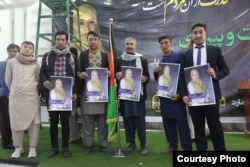 Supporters hold posters of Afghan parliamentary candidate Zuhra Nawrozi in Kabul on October 12