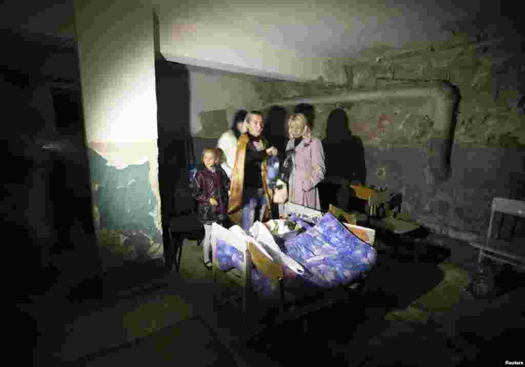 A family hides in a school basement that is being used as a shelter after recent shelling in Donetsk. (Reuters/Shamil Zhumatov) 