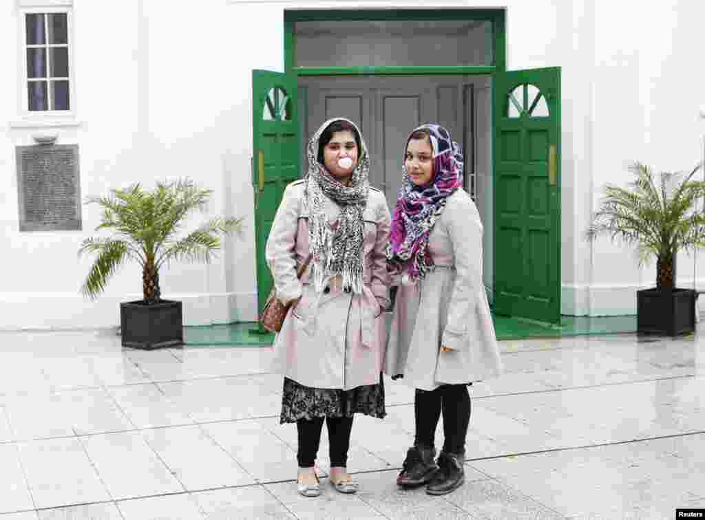 Madiha, 12, and Afsha, 11, pose outside London Mosque in west London. Both girls started to wear the hijab around the age of 8. They wear the hijab for religious observance, modesty, and to protect themselves.