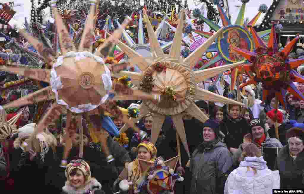 Lwowdaky parad mahalynda bezelen Betlehem ýyldyzlaryny göterip, Kristmas aýdymlaryny aýdýan ukrainalylar. 8-nji ýanwar.. (epa-EFE/Mykola Tys)