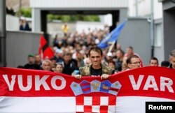 Мужчна несет флаг Хорвати во время протесов на акции протеста против сербоязычных указателей. Вуковар, сентябрь 2013 года