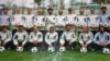 Mohammad Isaq (top right) poses with members of the Sabawoon 1999 soccer team at Ghazi Stadium in Kabul.