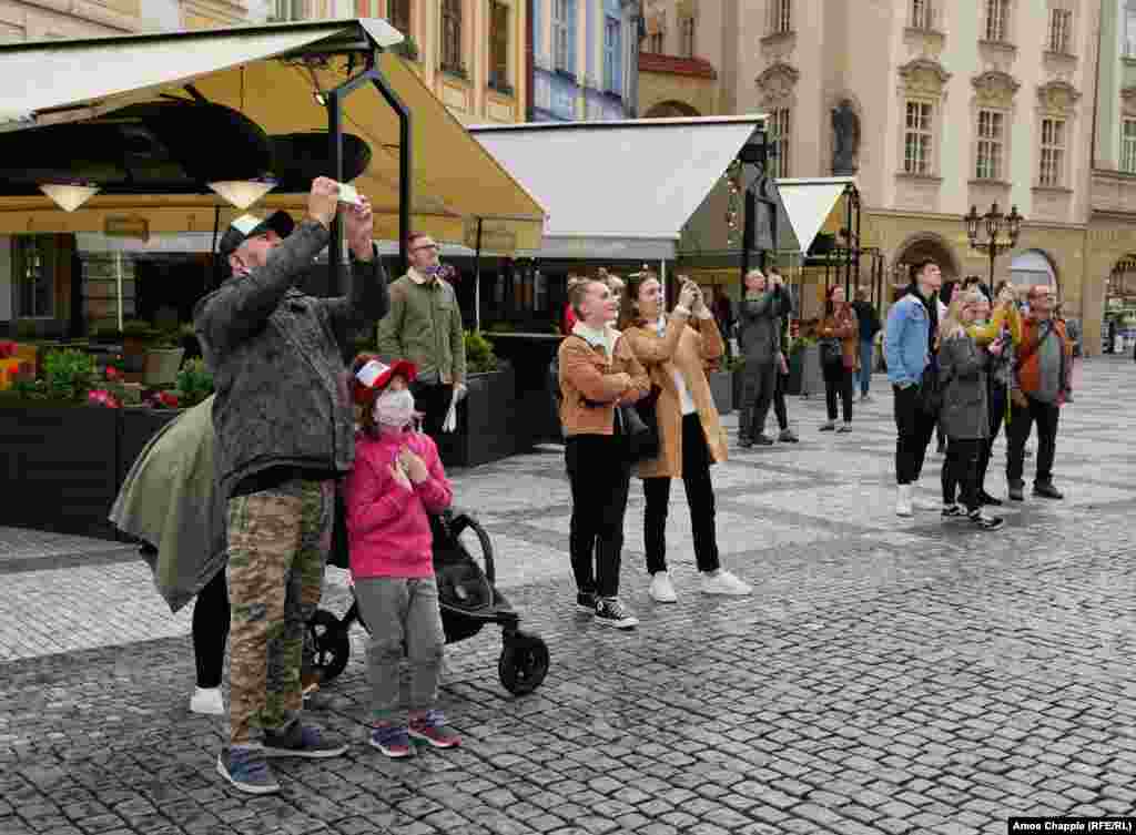 Невелика юрба, переважно чехів, спостерігає за дзвонами астрономічного годинника