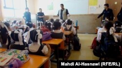 أحد عناصر دائرة الدفاع المدني يلقي محاضرة على طالبات في مدرسة بمحافظة ذي قار
