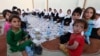 A group of young Afghans wait to eat iftar, the meal traditionally taken after sunset prayers to break the fast during the Islamic holy fasting month of Ramadan, in Herat.