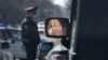 KAZAKHSTAN -- A person wearing a protective mask, used as a preventive measure against coronavirus disease (COVID-19), is reflected in the side mirror of a car near a Kazakh law enforcement officer in Almaty, March 30, 2020