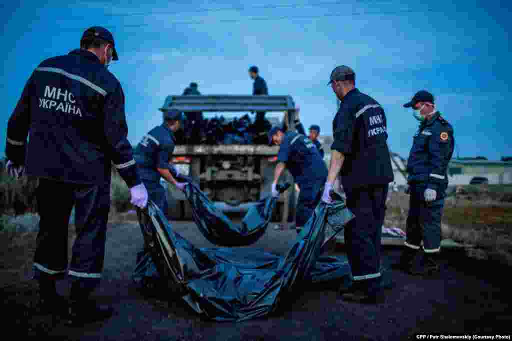 Third Prize,&nbsp;Spot News:&nbsp;Emergency&nbsp;workers carry the bodies of passengers on Flight&nbsp;MH17, which crashed&nbsp;near the village&nbsp;of Grabovo in&nbsp;eastern Ukraine. (Petr Shelomovskiy) 