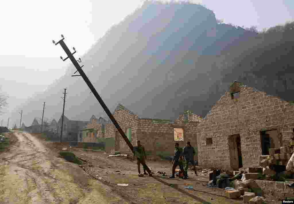 Ethnic Armenian soldiers topple a telephone pole in the village of Knaravan &ndash; a settlement recently built by ethnic Armenians in the Karvachar/Kalbacar district near Azerbaijan&rsquo;s border with Armenia.