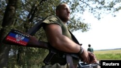 A pro-Russian separatist showing the "People's Republic of Donetsk" insignia guards a checkpoint near the village of Rozsypne on August 4.