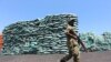 FILE PHOTO: A Somalian soldier walks past a consignment of charcoal destined for the export market in Barawe October 12, 2014. REUTERS/Feisal Omar (SOMALIA)/File Photo