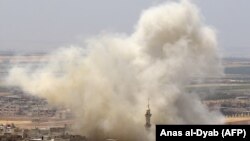 Клубы дыма на месте вероятного авиаудара в городе Хан-Шейхун в удерживаемой повстанцами сирийской провинции Идлиб. 3 июня 2019 года.