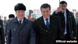 Қырғызстан президенті Сооронбай Жээнбеков (ортада) әуежайда өзін күтіп алған Қазақстан премьер-министрінің бірінші орынбасары Асқар Мәминмен (сол жақта) кетіп барады. Астана, 25 желтоқсан 2017 жыл.