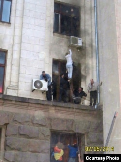 Проукраинские активисты помогают эвакуировать людей из горящего здания Дома профсоюзов. Одесса, 2 мая 2014 года