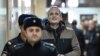 Dennis Christensen is escorted into the courtroom to hear his verdict in the town of Oryol on February 6.