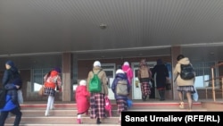Ученицы общеобразовательной школы на западе Казахстана в сопровождении родителей идут на занятия. Иллюстративное фото.