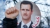 A supporter of Syrian President Bashar al-Assad raises a clenched fist at a protest near the hotel where the 'Geneva II' peace talks opened on January 22, in Montreux.