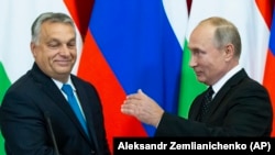 Hungarian Prime Minister Viktor Orban (left) and Russian President Vladimir Putin hold a joint news conference after their talks in the Kremlin in Moscow on September 18.
