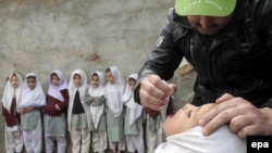 Pakistan -- A health worker administers a polio vaccine to a child during a three-day nationwide vaccination campaign to eradicate polio, in Afghan Basti area of Islamabad, January 21, 2014