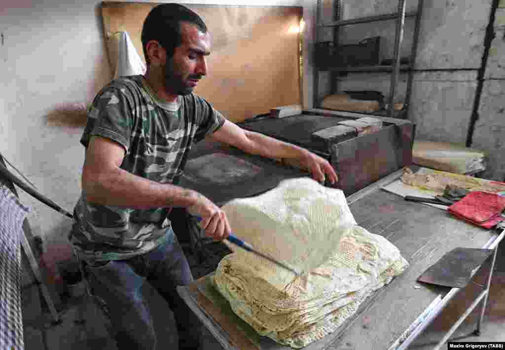 A baker in Stepanakert cooks traditional Armenian flatbread on November 25. A recently returned resident said the 2020 conflict was the worst the city had experienced, telling a Reuters reporter: &quot;I have seen the third war already here. In 1992 and 2016 I did not leave the city for even a minute. But this time it was awful.&quot;