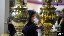 A woman prepares tea at a booth representing Iran at the 49th International Tourism Fair (ITB Berlin 2015) in Berlin on March 4, 2015.