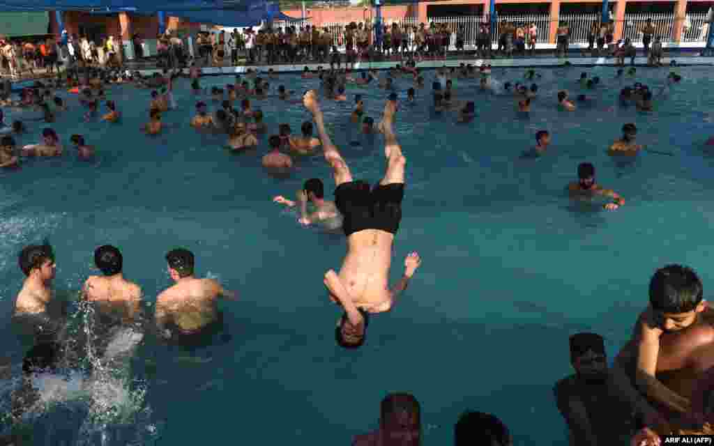 Pakistani youth cool down at a swimming pool during a a hot day in Lahore. (AFP/Arif Ali)