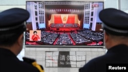 Китайские полицейские смотрят ТВ-трансляцию речи председателя Си Цзиньпина на XIX съезде Коммунистической партии Китая.