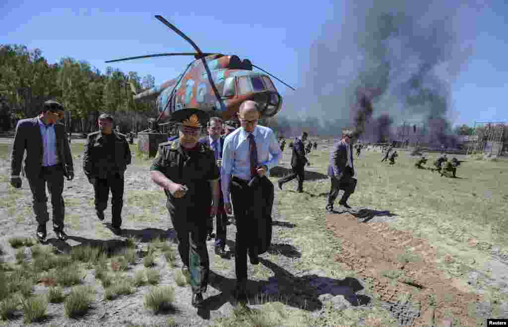 Ukrainian Prime Minister Arseniy Yatsenyuk (center) walks with officers and officials during a visit to the training camp of the National Guard near Kyiv on May 22. (Reuters/ Andrew Kravchenko)