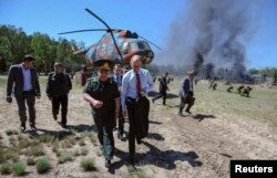 Ukrainian Prime Minister Arseniy Yatsenyuk (center with tie) walks with officers and officials during a visit to a National Guard training camp near Kyiv on May 22.