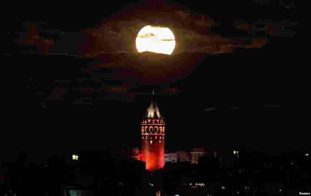 Взгляд в луну над исторической башней Галата на Босфоре в Стамбуле, Турция.