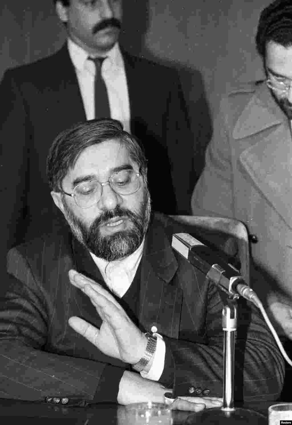 Iranian Prime Minister Mir Hossein Musavi answers questions during a press conference at Ankara airport, on February 17, 1989. He said that Iran saw Rushdie&#39;s &quot;The Satanic Verses&quot; as a kind of conspiracy against Islamic principles.