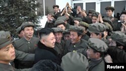 Kim Jong Un (center) celebrates with scientists and technicians after the launch of a rocket in mid-December.