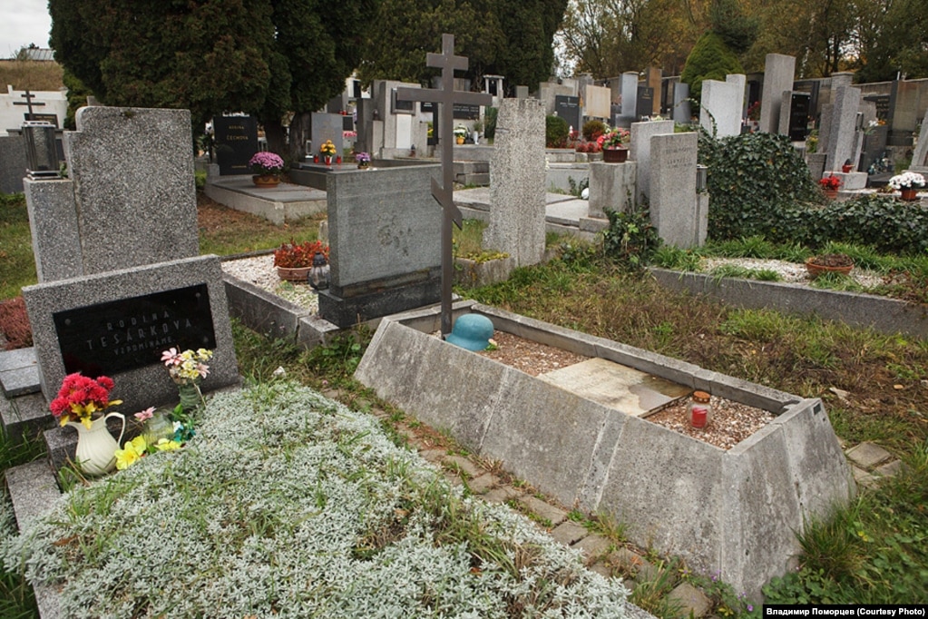 Немецкая каска на могиле с православным крестом в пражском районе Ржепы