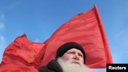 A demonstrator with a red Soviet flag attends a protest rally in Barnaul.