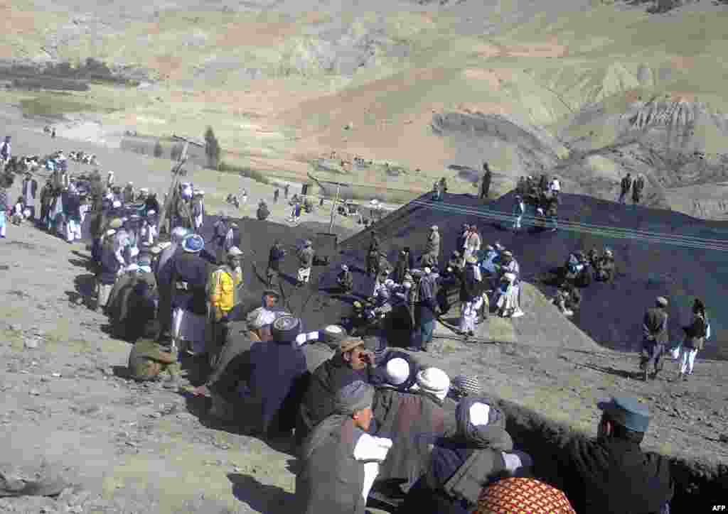 Miners sit at the entrance of a collapsed mine, September 15, 2013.