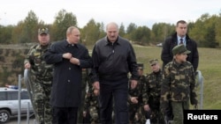 Президент России Владимир Путин (слева) и его белорусский коллега Александр Лукашенко (справа) с его сыном идут наблюдать за завершающим этапом совместных военных учений «Запад-2013» на полигоне в Гродно. Беларусь, сентябрь 2013 года