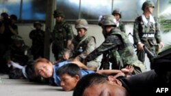 Antigovernment protesters are detained by soldiers inside their camp in Bangkok on May 19.