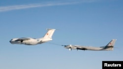 Ресейдің Ту-95 стратегиялық бомбалаушы ұшағына әуеден жанармай құю сәті. (Көрнекі сурет).