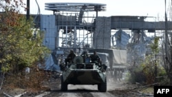 Pro-Russian armored vehicles drive down a road leading to the destroyed Luhansk International Airport, in eastern Ukraine, on September 11.